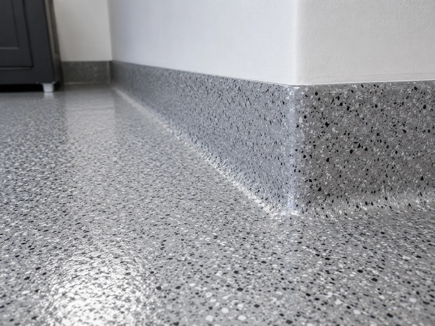Coved epoxy base where a basement floor curves up into the wall
