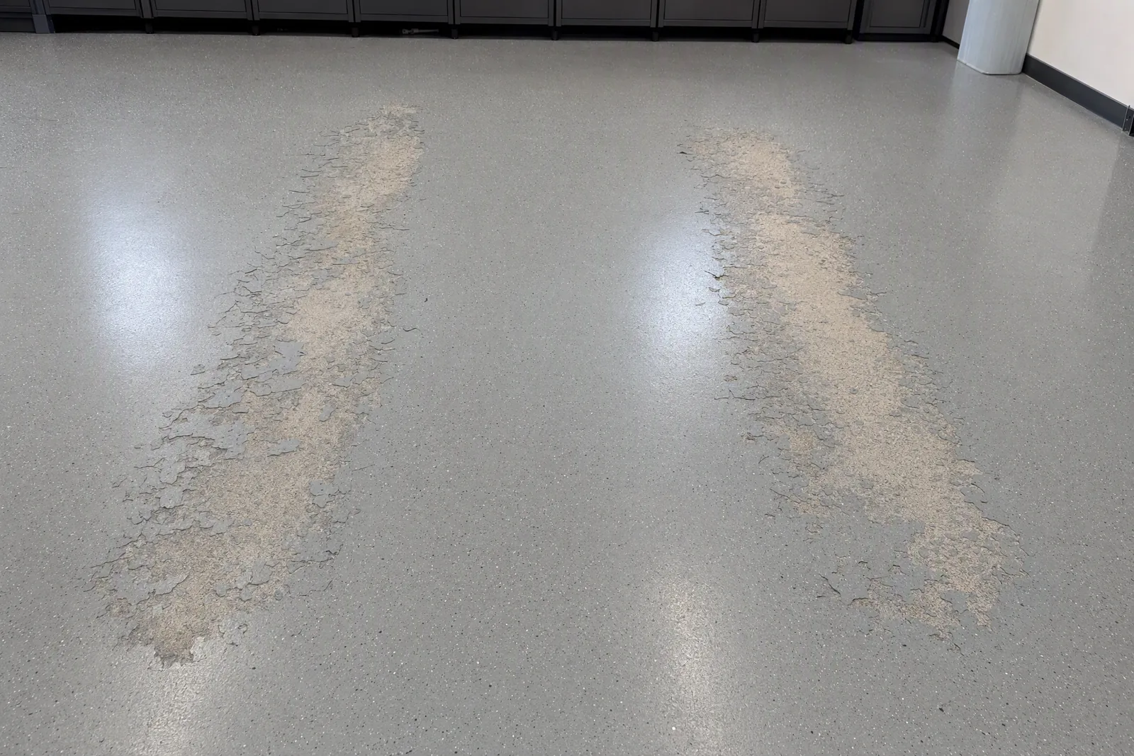 Floor coating lifted in two tire-width patches from hot tire pickup