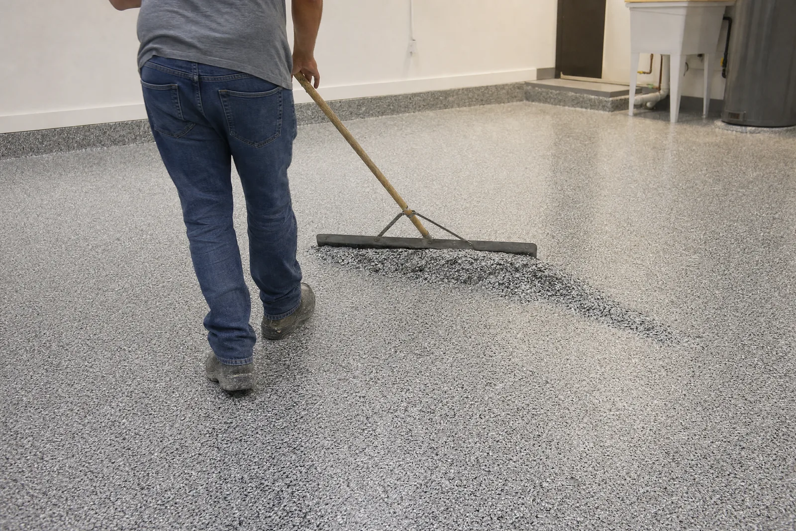 Floor scraper knocking down sharp chip edges on a cured flake floor