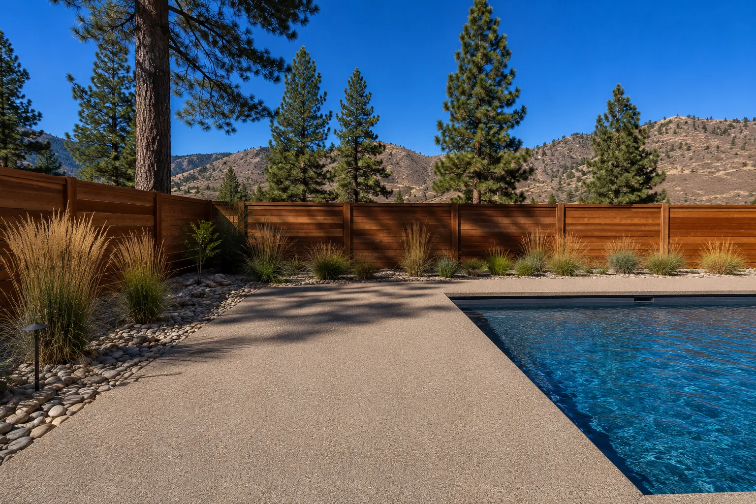 Residential pool deck with textured tan quartz broadcast coating beside a swimming pool