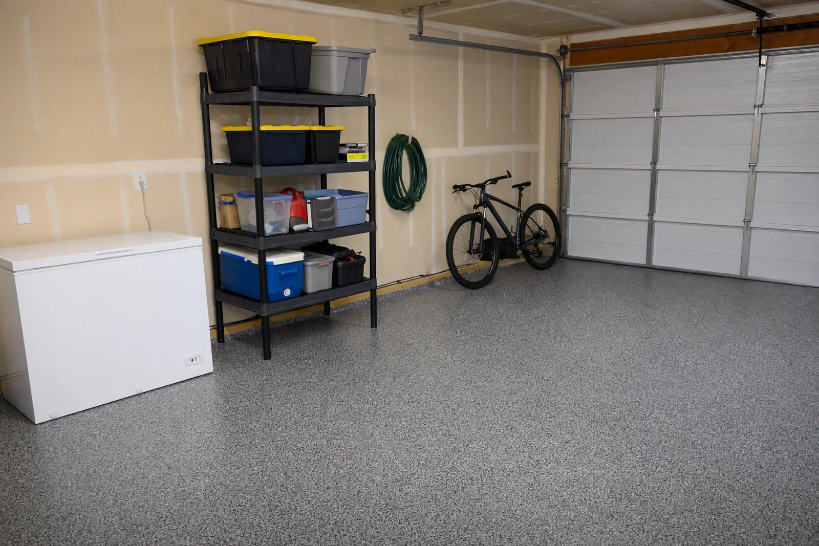 Ordinary lived-in residential garage with a grey and black flake epoxy floor